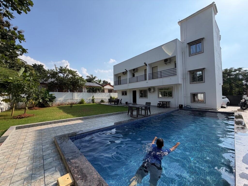 Nandan Villa, Karjat: the white villa, the blue pool and the lawn on a clear day