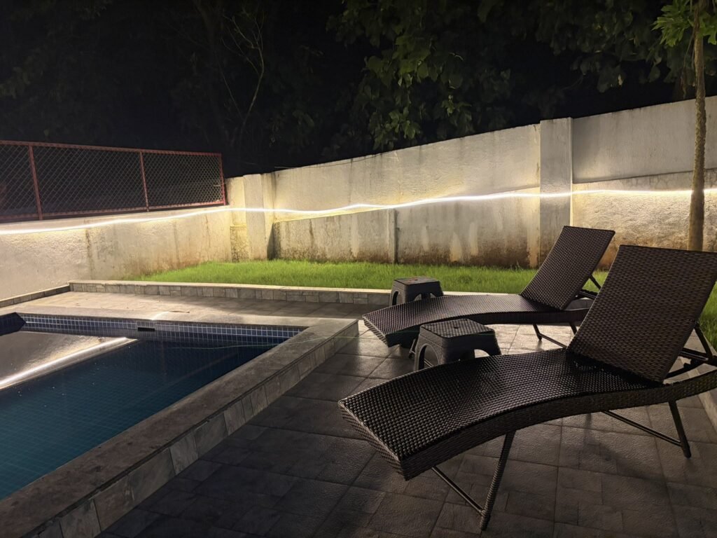 Nandan Villa, Karjat: Sun loungers on the pool deck at night